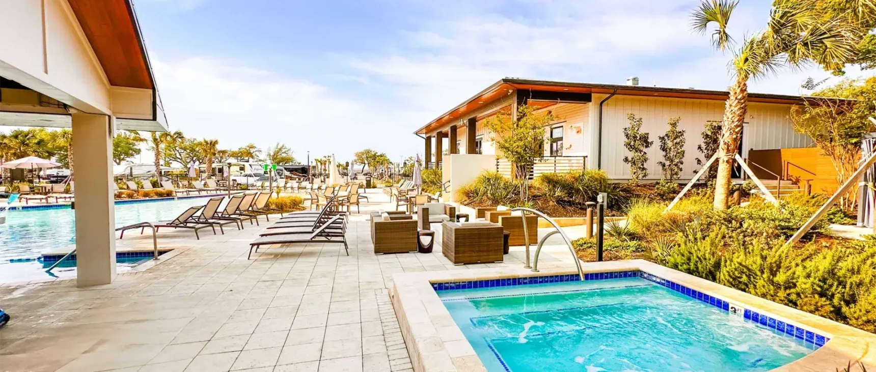 Pool view surrounded by chairs and beach landscaping.