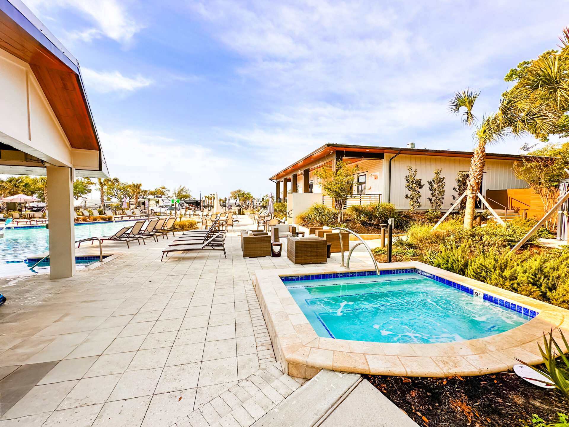 Hot Tub View Pool view surrounded by chairs and beach landscaping.